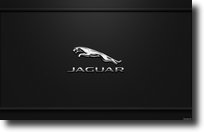 Logo marque voiture Jaguar au milieu de l'image sur fond noir. 